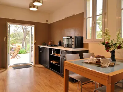 a kitchen with a table with chairs and a counter top at Holiday Home Weingut Punta della guardia zwischen Meer und Gebirge by Interhome in Cervione