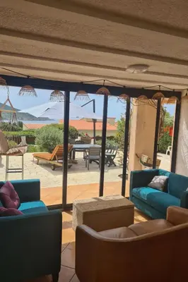 a living room with couches and a view of a patio at Holiday Home Casa zinu mit Blick aufs Meer by Interhome in Cargèse