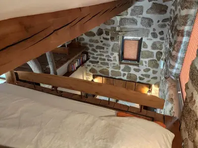a bed in a room with a stone wall at Holiday Home in idyllischer Lage im Süden Korsikas by Interhome in Serra-di-Ferro