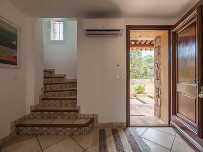 a hallway with stairs and a door to a yard at Holiday Home Luxusvilla aus Stein Concadoro by Interhome in Porto-Vecchio