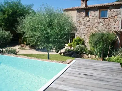 a house with a swimming pool and a wooden walkway at Holiday Home Luxusvilla aus Stein Concadoro by Interhome in Porto-Vecchio