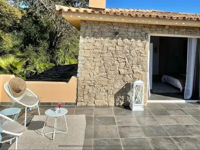 a patio with chairs and a table and a building at Holiday Home Villa Casa Baggia- nahe am Meer mit eigenem Schwimmbad by Interhome in Porto-Vecchio