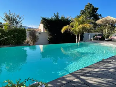 a swimming pool with blue water in a yard at Holiday Home Villa Casa Baggia- nahe am Meer mit eigenem Schwimmbad by Interhome in Porto-Vecchio