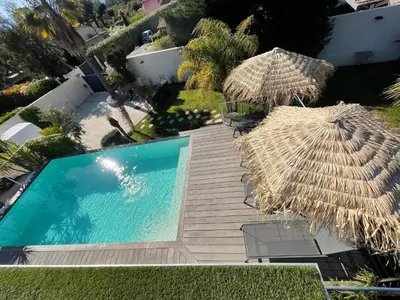 an overhead view of a swimming pool with a straw umbrella and chairs at Holiday Home Villa Casa Baggia- nahe am Meer mit eigenem Schwimmbad by Interhome in Porto-Vecchio