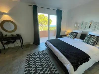 a bedroom with a bed and a table and a window at Holiday Home Ferienvilla Azura mit eigenem Pool by Interhome in Pascialello