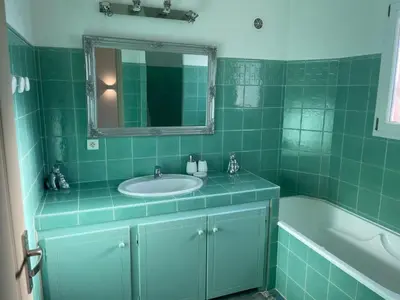 a green tiled bathroom with a sink and a tub at Holiday Home Ferienvilla Azura mit eigenem Pool by Interhome in Pascialello