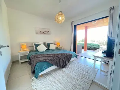 a bedroom with a bed and a sliding glass door at Holiday Home Villa Santa Giulia in Porto-Vecchio by Interhome in Porto-Vecchio