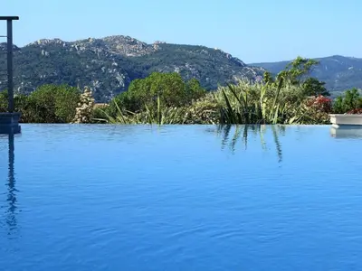 a large body of water with mountains in the background at Holiday Home Villa Santa Giulia in Porto-Vecchio by Interhome in Porto-Vecchio
