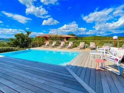 a swimming pool on a wooden deck with chairs around it at Holiday Home Villa Santa Giulia in Porto-Vecchio by Interhome in Porto-Vecchio