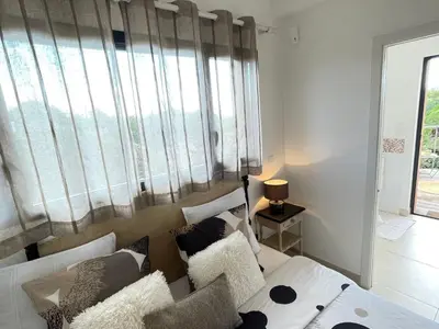 a living room with a white couch and a large window at Holiday Home Villa Santa Giulia in Porto-Vecchio by Interhome in Porto-Vecchio