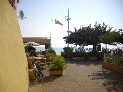 a patio with a table and chairs and the ocean at Apartment Sole e Ventu 50qm by Interhome in San-Giovanni-di-Moriani