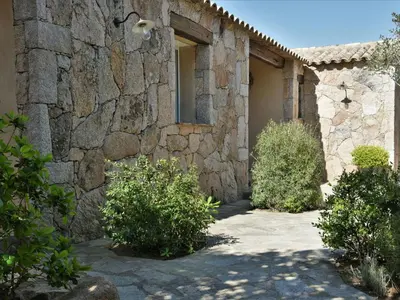 a stone building with bushes in front of it at Holiday Home Luxuriöse Schäferei 2km vom Strand von Santa Giulia entfernt by Interhome in Porto-Vecchio