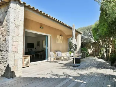a patio with a table and chairs and an umbrella at Holiday Home Luxuriöse Schäferei 2km vom Strand von Santa Giulia entfernt by Interhome in Porto-Vecchio