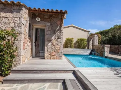 a house with a swimming pool and a wooden walkway at Holiday Home Luxuriöse Schäferei 2km vom Strand von Santa Giulia entfernt by Interhome in Porto-Vecchio