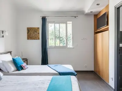 two beds in a room with a window at Holiday Home Luxuriöse Schäferei 2km vom Strand von Santa Giulia entfernt by Interhome in Porto-Vecchio