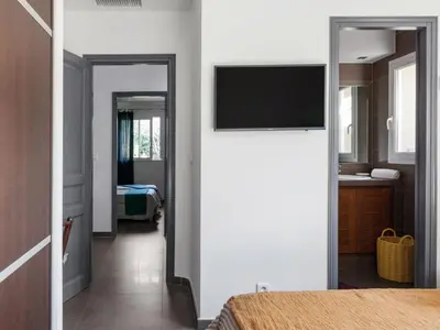 a bedroom with a flat screen tv on a wall at Holiday Home Luxuriöse Schäferei 2km vom Strand von Santa Giulia entfernt by Interhome in Porto-Vecchio