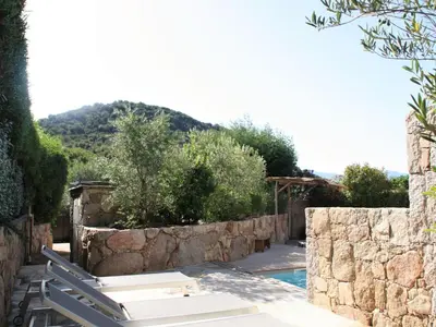 a resort with a pool and a stone wall at Holiday Home Luxuriöse Schäferei 2km vom Strand von Santa Giulia entfernt by Interhome in Porto-Vecchio