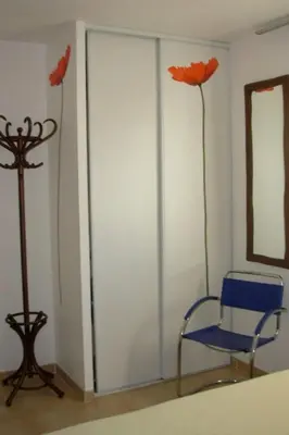 a room with a blue chair and two fake flowers at Holiday Home Villa Miramonte by Interhome in Venzolasca