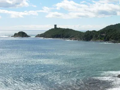 a lighthouse on a small island in the ocean at Holiday Home Villa Miramonte by Interhome in Venzolasca