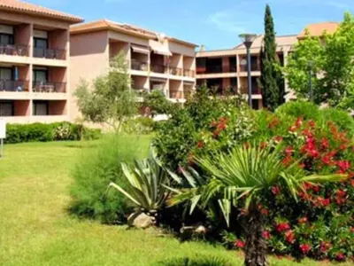 a large apartment building with a yard with plants at Apartment Blaue Flucht Korsika by Interhome in San-Nicolao