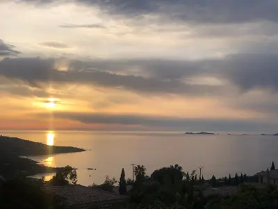 a sunset over a body of water with the sun setting at Villa Pierretti - Vue mer Panoramique in Coti-Chiavari