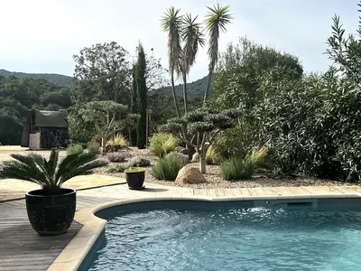 a swimming pool in a garden with palm trees at Villa Pierretti - Vue mer Panoramique in Coti-Chiavari