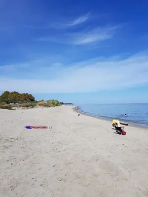 a sandy beach with a yellow umbrella and the ocean at Apartment with Garden - Two Pools - Beach Access in Poggio-Mezzana
