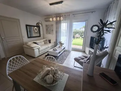 a living room with a table and a couch at Apartment with Garden - Two Pools - Beach Access in Poggio-Mezzana