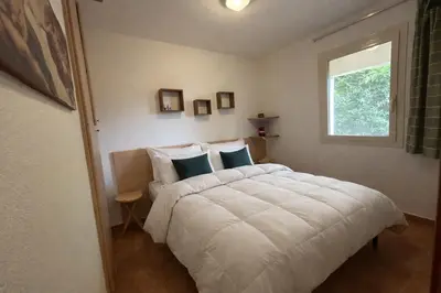 a bedroom with a white bed and a window at Appartement avec piscines et plage à pied in Linguizzetta