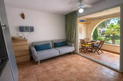 a living room with a couch and a table at Appartement avec piscines et plage à pied in Linguizzetta