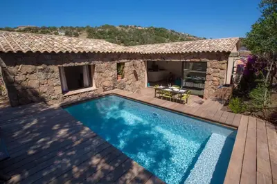 a villa with a swimming pool and a house at Les Bergeries de Porra in Porto-Vecchio
