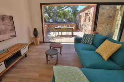 a living room with a blue couch and a table at Les Bergeries de Porra in Porto-Vecchio