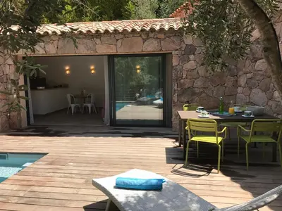 a patio with a table and chairs and a pool at Les Bergeries de Porra in Porto-Vecchio