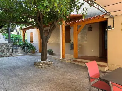 a patio with a tree and a table and chairs at Maison de caractère CASA LECA, piscine privée chauffée in Feliceto