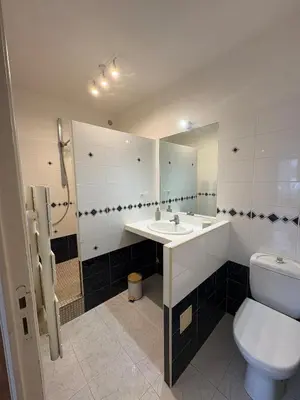 a bathroom with a toilet and a sink and a mirror at Appartement T3 plein centre bord de mer in Propriano
