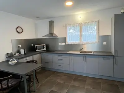 a kitchen with white cabinets and a sink and a table at Maison in Linguizzetta