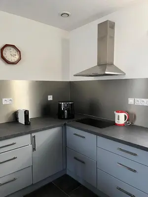 a kitchen with white cabinets and a clock on the wall at Maison in Linguizzetta