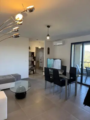 a living room with a glass table and chairs at L'Immortelle - T3 avec balcon vue mer & montagne in Calenzana