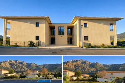 a large house with mountains in the background at L'Immortelle - T3 avec balcon vue mer & montagne in Calenzana