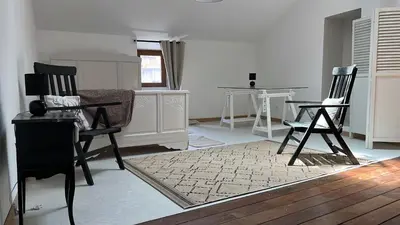 a living room with two chairs and a table at Appartement dans le coeur de Sartène, la plus corse des villes corses in Sartène