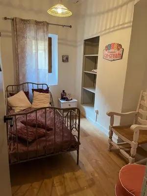 a bedroom with a bed and a chair at Appartement dans le coeur de Sartène, la plus corse des villes corses in Sartène