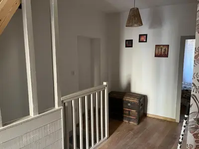 a hallway with a staircase with a wooden floor at Appartement dans le coeur de Sartène, la plus corse des villes corses in Sartène