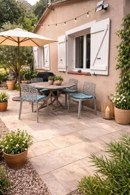 a patio with a table and chairs and an umbrella at Maison entre mer et montagne in Conca