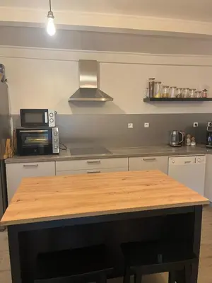 a kitchen with a wooden table and a microwave at Maison entre mer et montagne in Conca