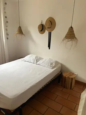 a bed in a room with two hats on the wall at Maison entre mer et montagne in Conca