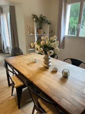 a wooden table with a vase of flowers on it at Maison entre mer et montagne in Conca