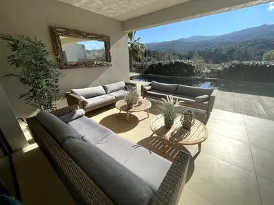 a living room with couches and tables and a view at La Villa K, plage du Ruppione in Pietrosella