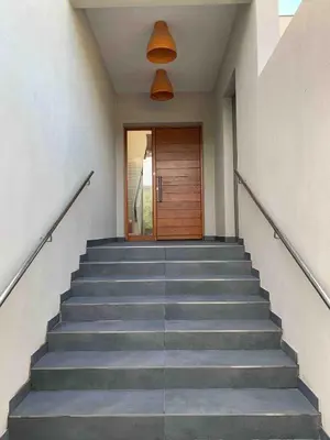 a stairway with a wooden door and a stair case at La Villa K, plage du Ruppione in Pietrosella