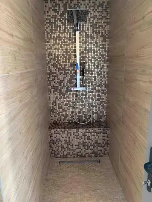 a shower with a shower head in a tiled bathroom at La Villa K, plage du Ruppione in Pietrosella
