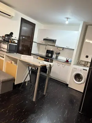 a kitchen with a table and a washing machine at T2 centre Ajaccio in Ajaccio